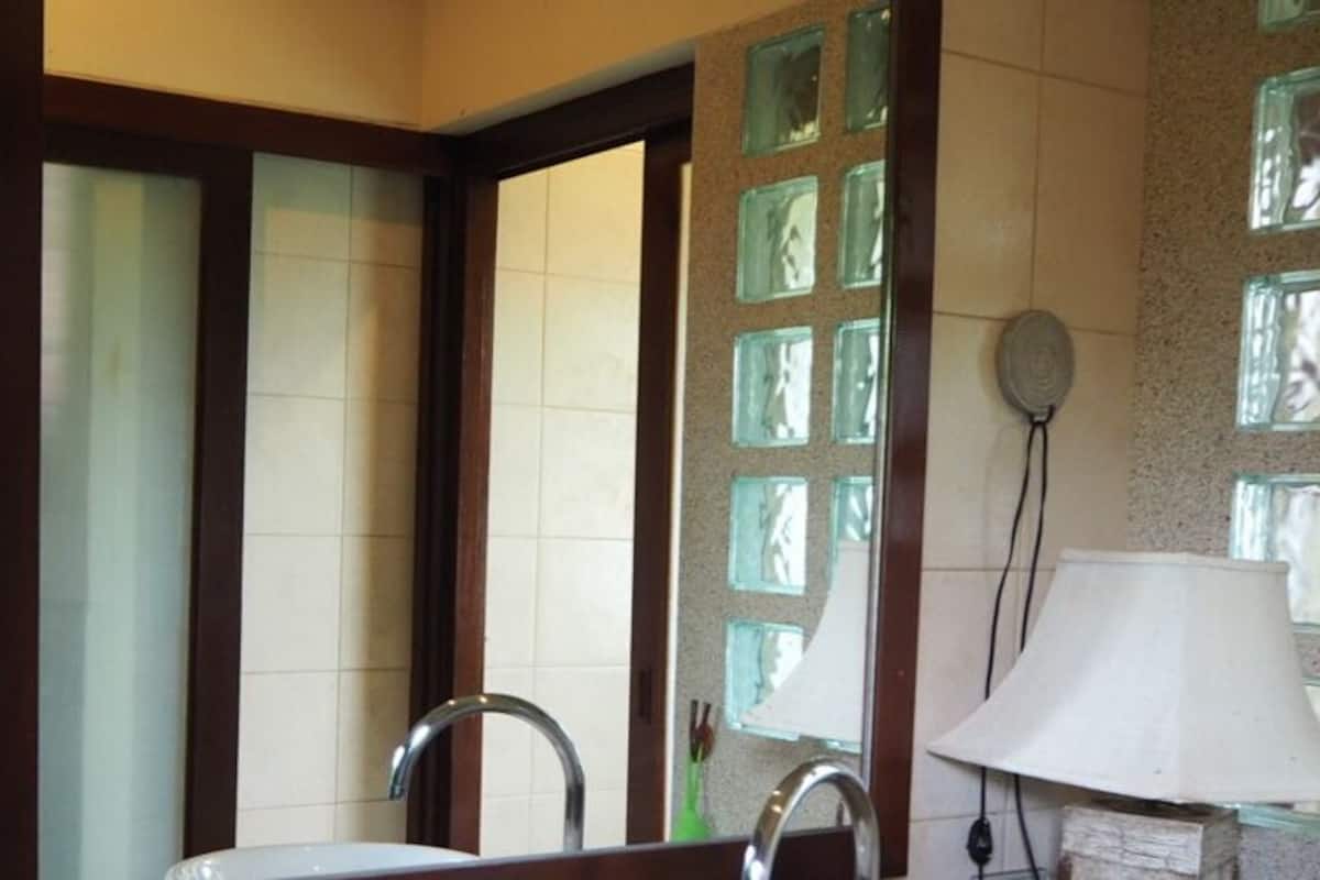 Un baño con lavamanos, espejo y un adorno en la pared.