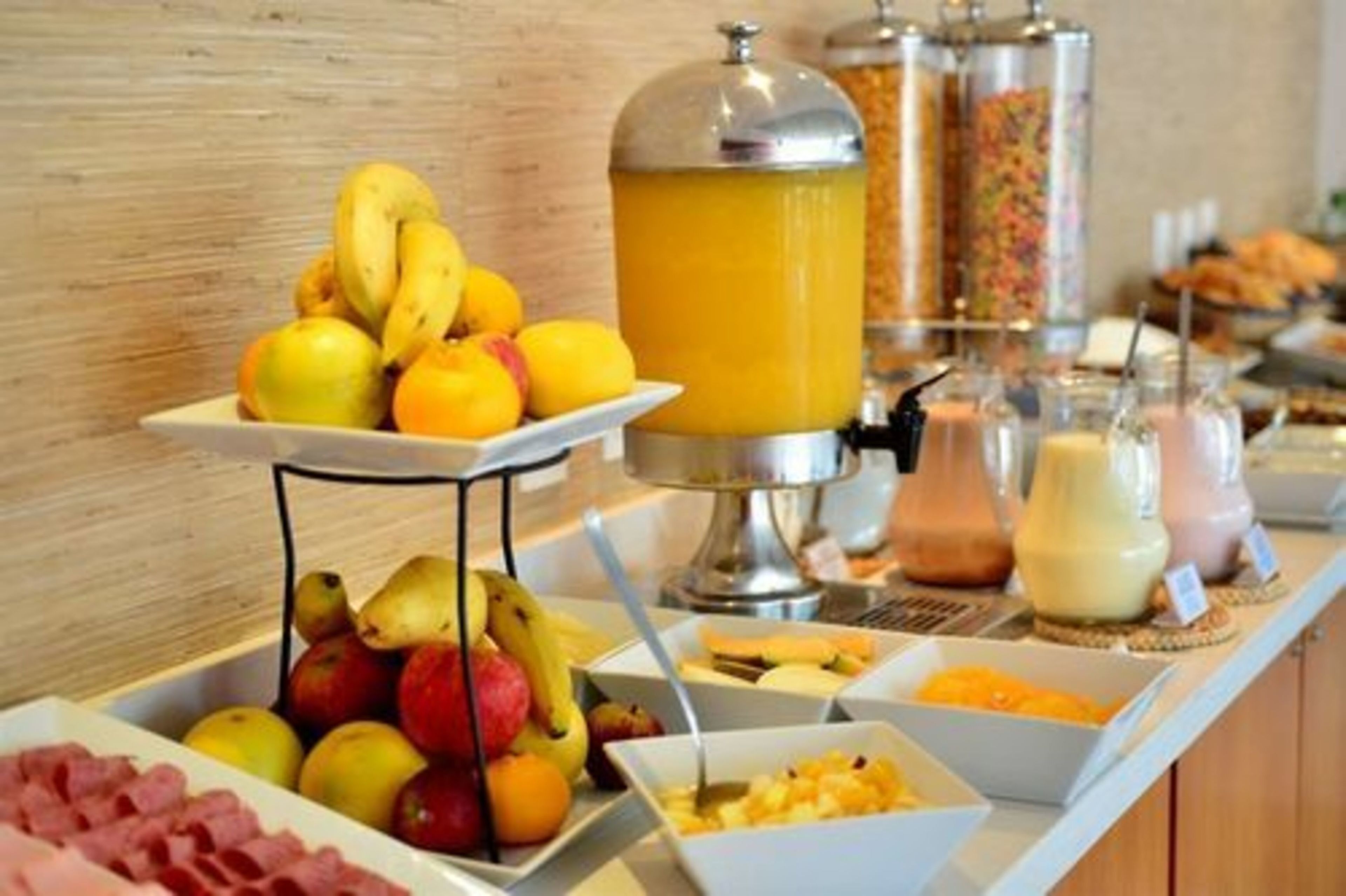 Un buffet proposant des fruits, des jus de fruits et divers plats.