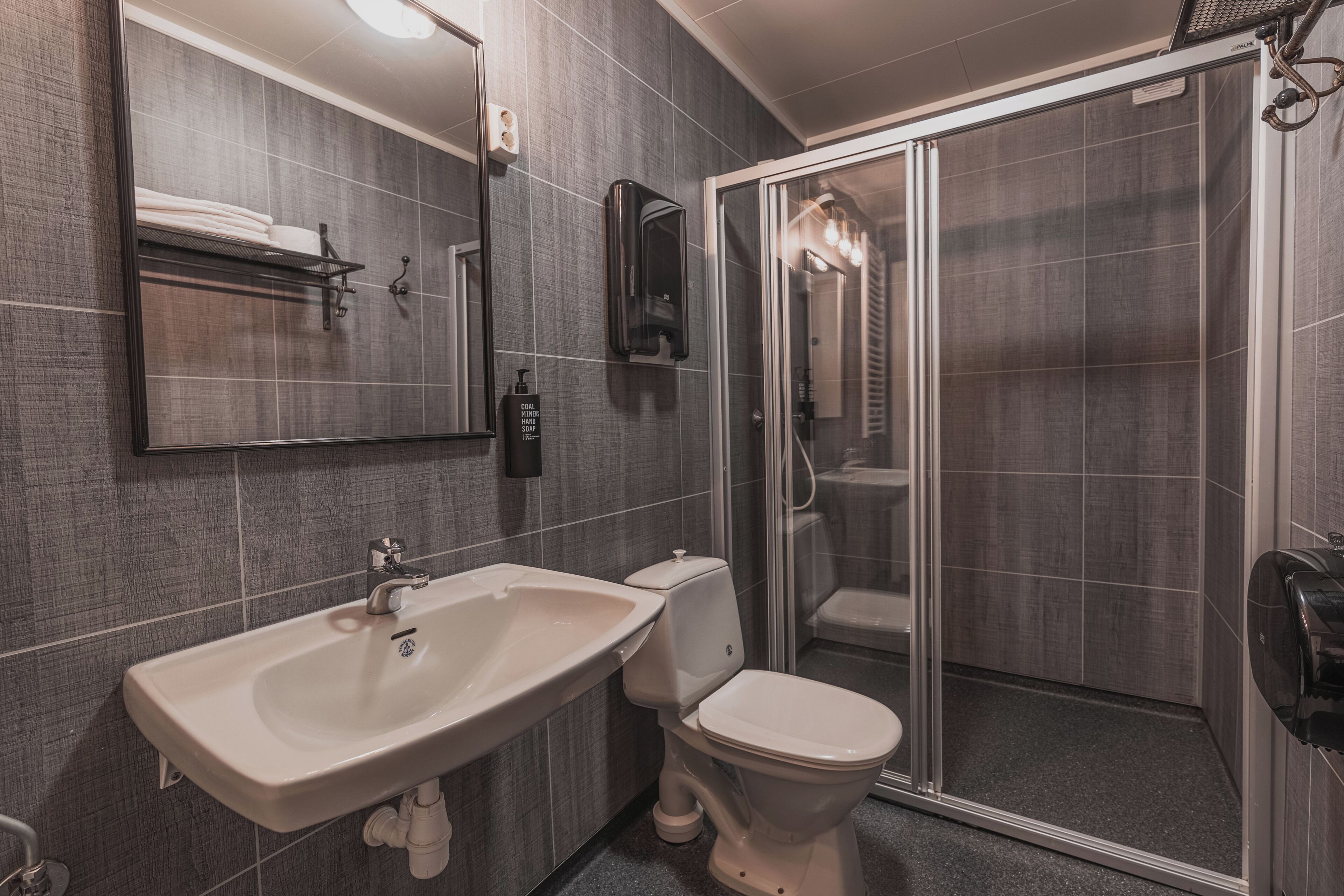 A modern bathroom with a sink, toilet, and glass-enclosed shower.