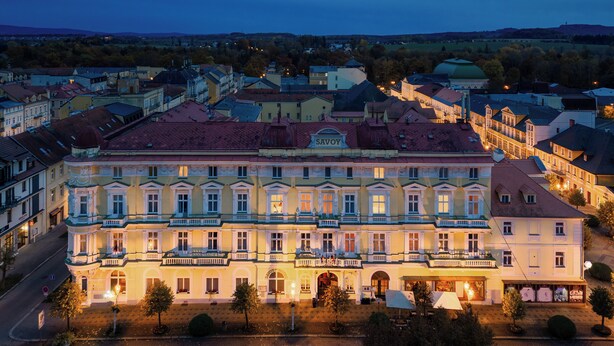 A large, historic building with multiple balconies and a central courtyard, surrounded by other buildings. - Spa Hotel Savoy (Frantiskovy Lazne)