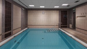 A swimming pool with tiled walls and a clock on the wall. - Spa Hotel Savoy (Frantiskovy Lazne)
