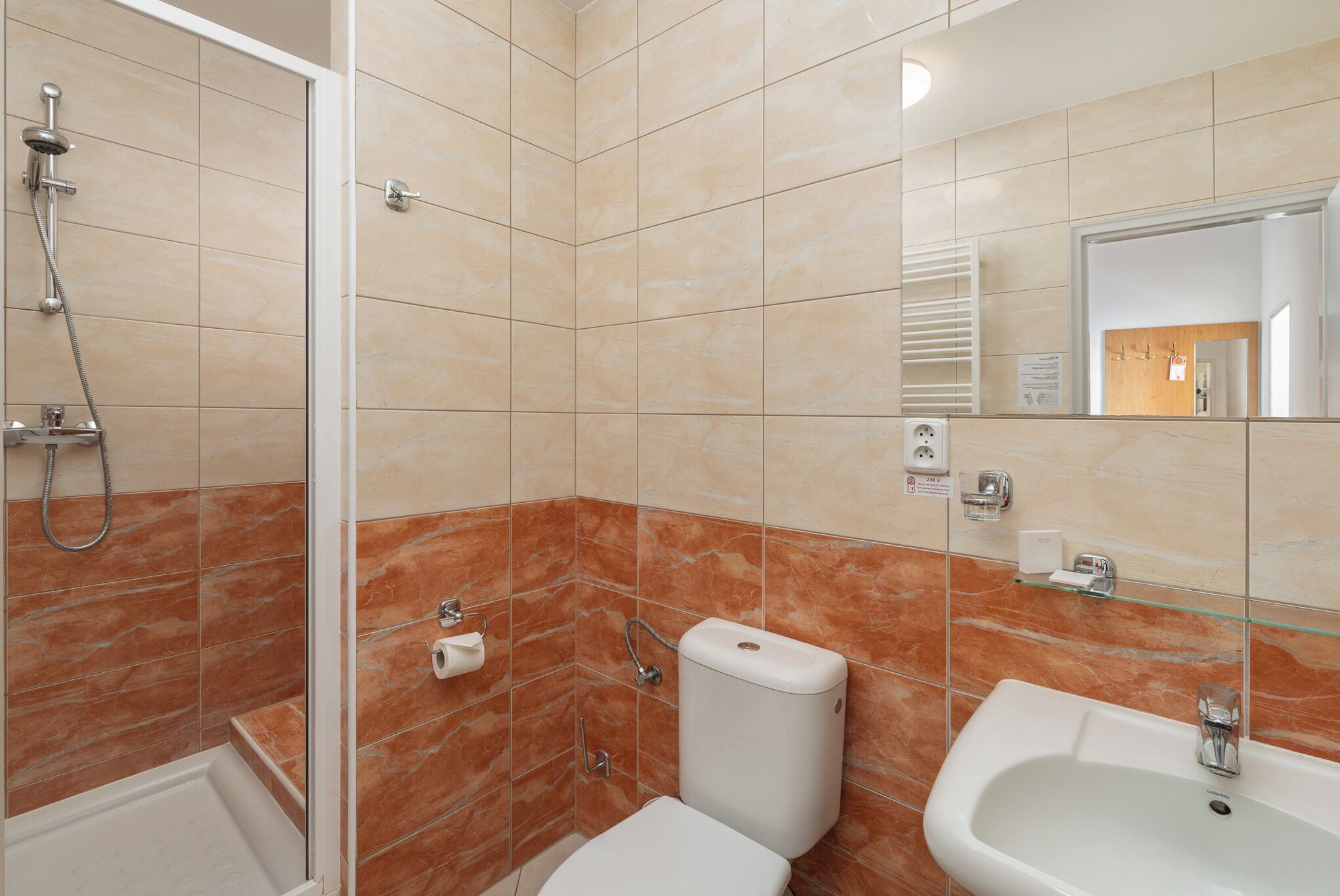 A bathroom with a shower, toilet, and sink.