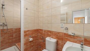 Un baño con ducha, inodoro y lavamanos.