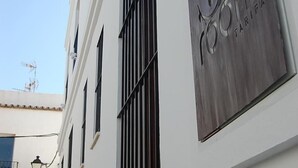 En bygning med et skilt, der står "room tarifa", og et vindue med lodrette sprosser.