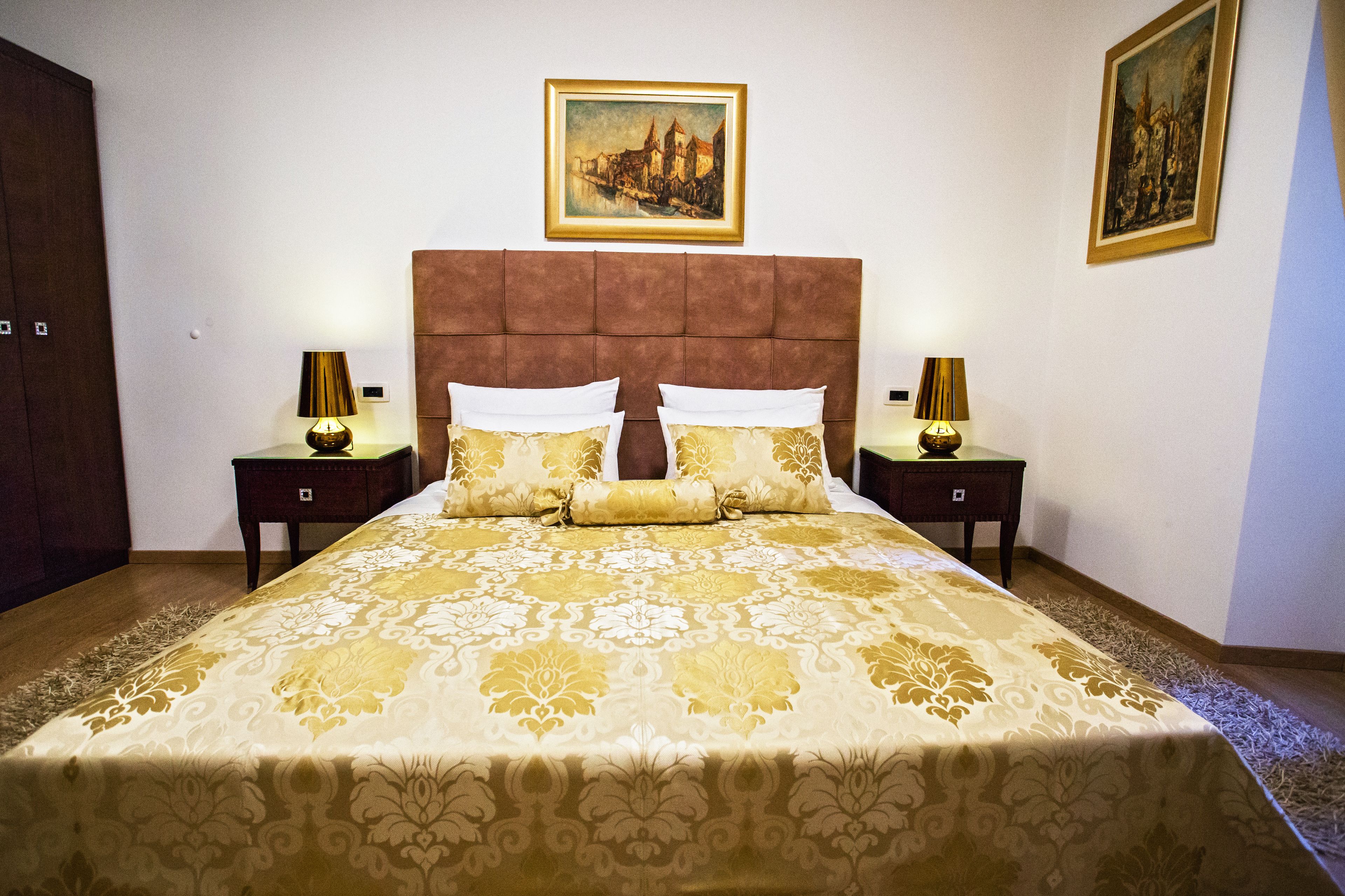 A bedroom with a large bed, two nightstands, and two lamps.