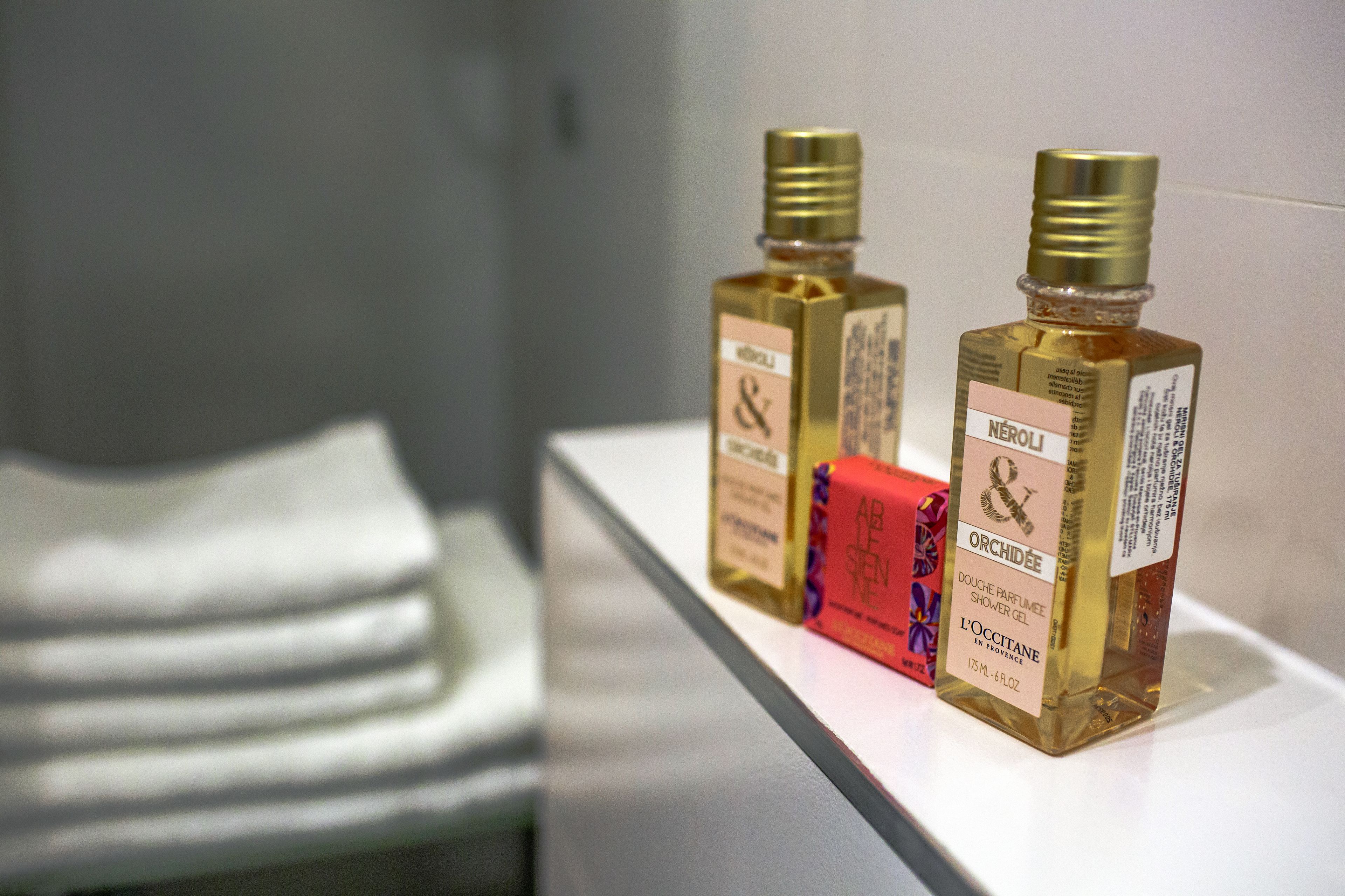 Two bottles of perfume on a shelf.