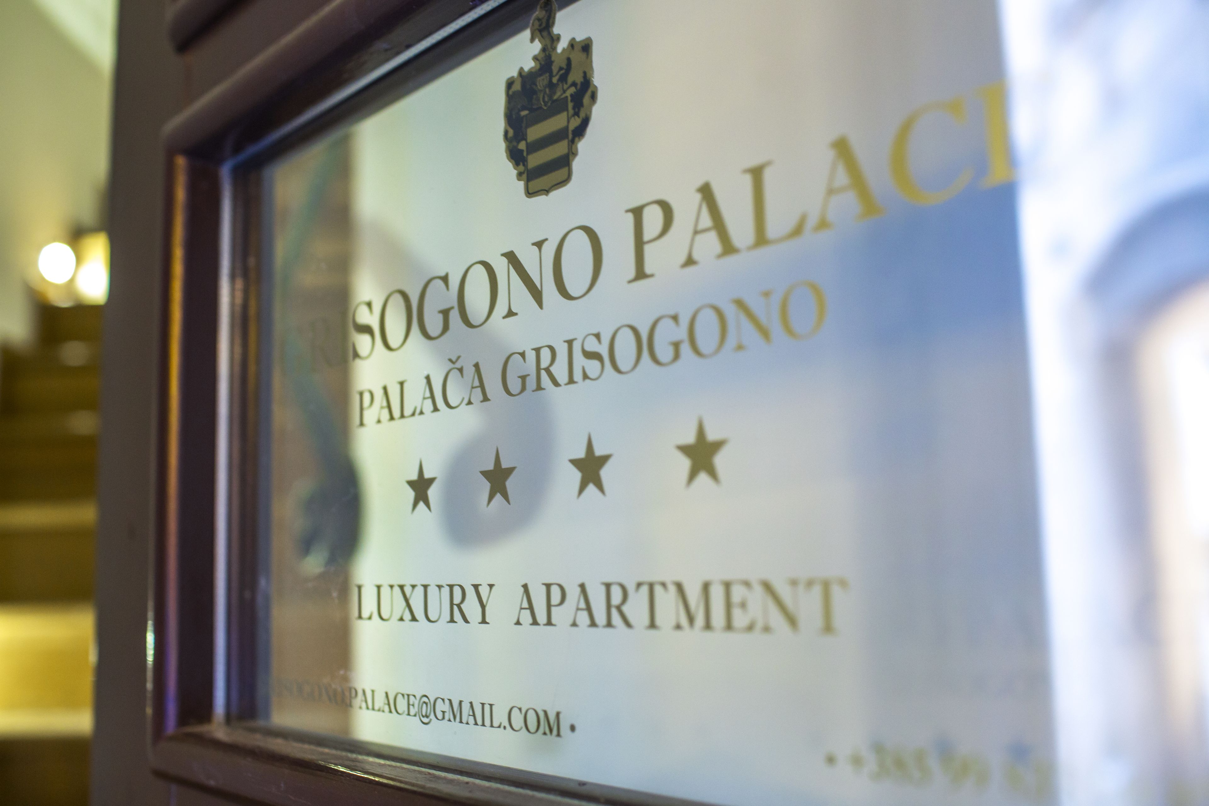 Een bord met de tekst 'SOGONO PALACE' en 'PALACE GRISOGONO LUXURY APARTMENT'.