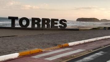 A beachside road with a large sign reading "TORRES".