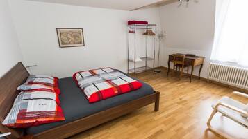 A bedroom with a wooden bed, a desk, and a chair.