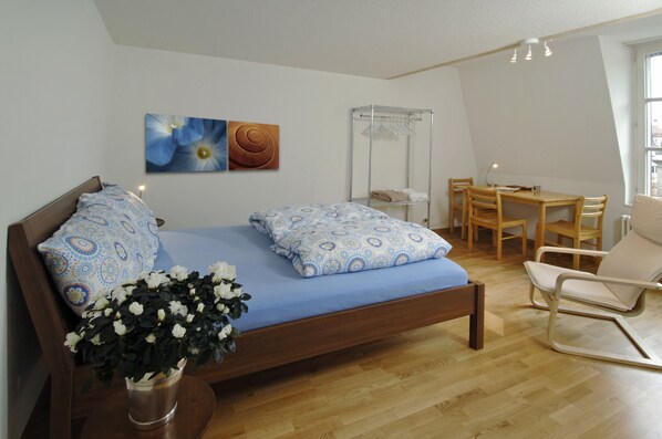A bedroom with a wooden bed, a desk, and a chair.