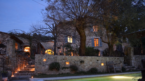 A stone building with a pool, steps leading to a door, and a bench. - Les Rosées (Mougins)