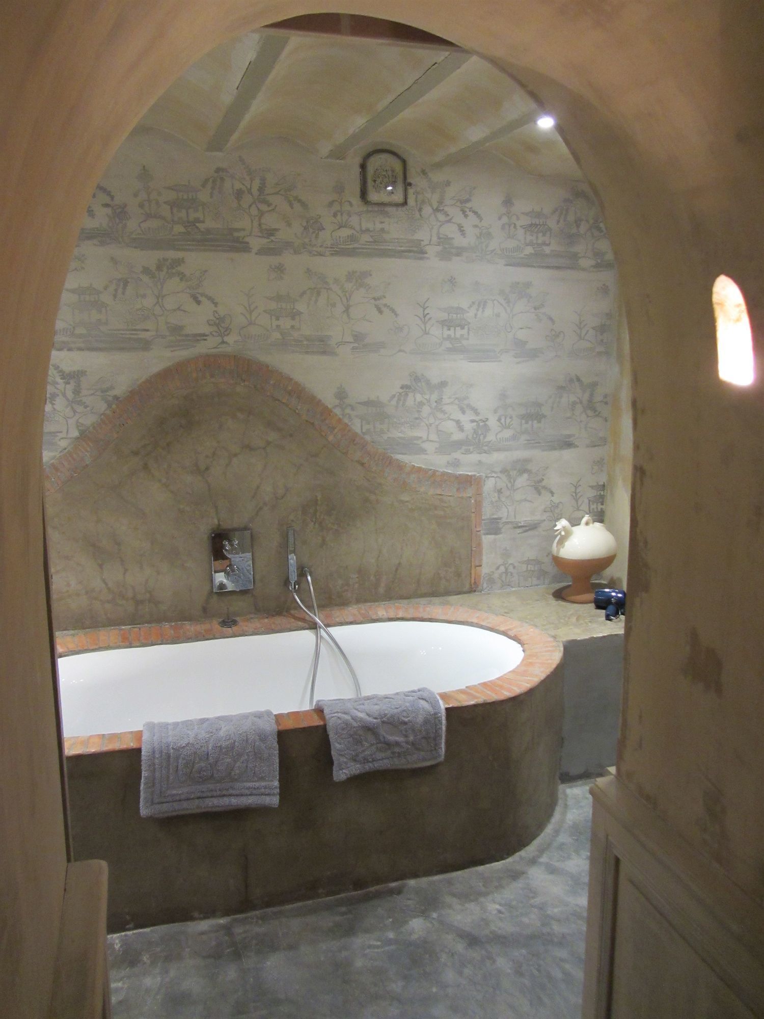 Un baño con una bañera independiente, un perchero y un zócalo decorativo.
