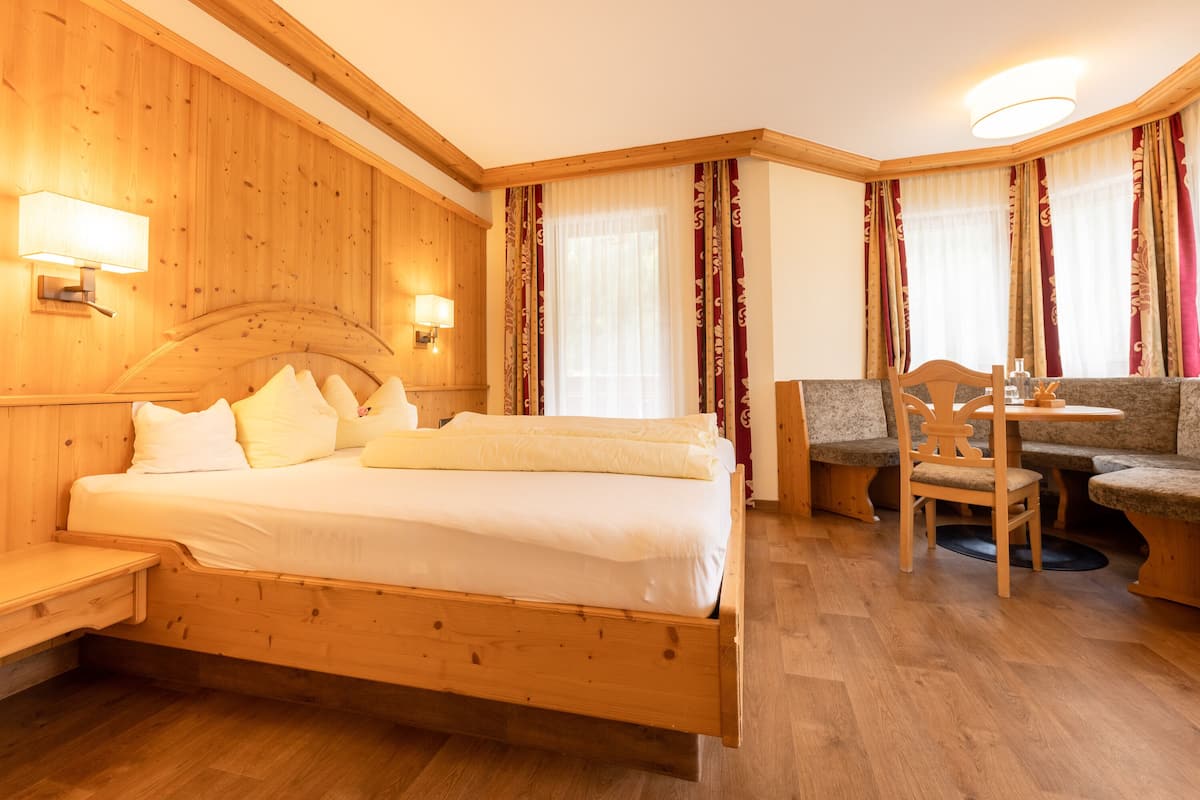 A wooden room with a bed, a desk, and a chair.