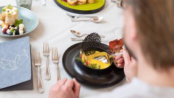 Une table à manger avec une assiette de nourriture, des couverts et une serviette.
