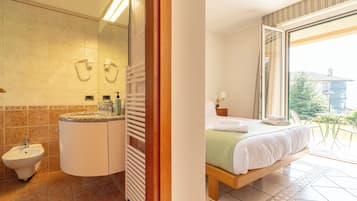 Tweepersoonskamer, uitzicht op tuin, bijgebouw | Donsdekens, een kluis op de kamer, een bureau, verduisterende gordijnen