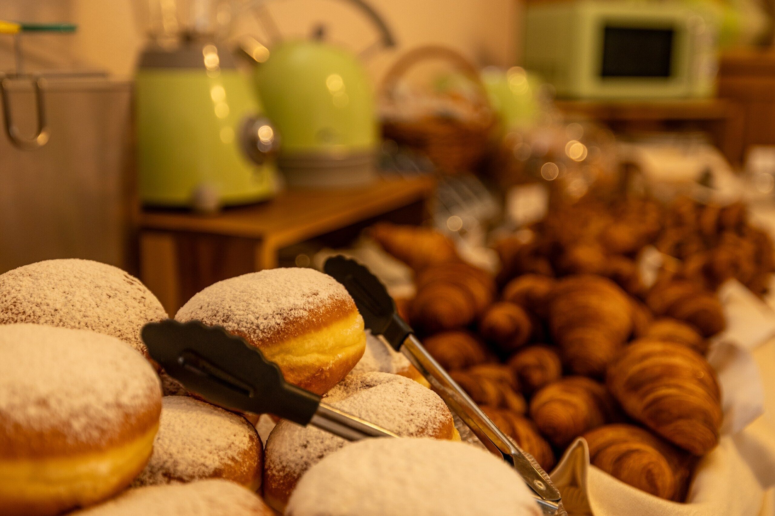 Un buffet con dolci e un elettrodomestico verde sullo sfondo.