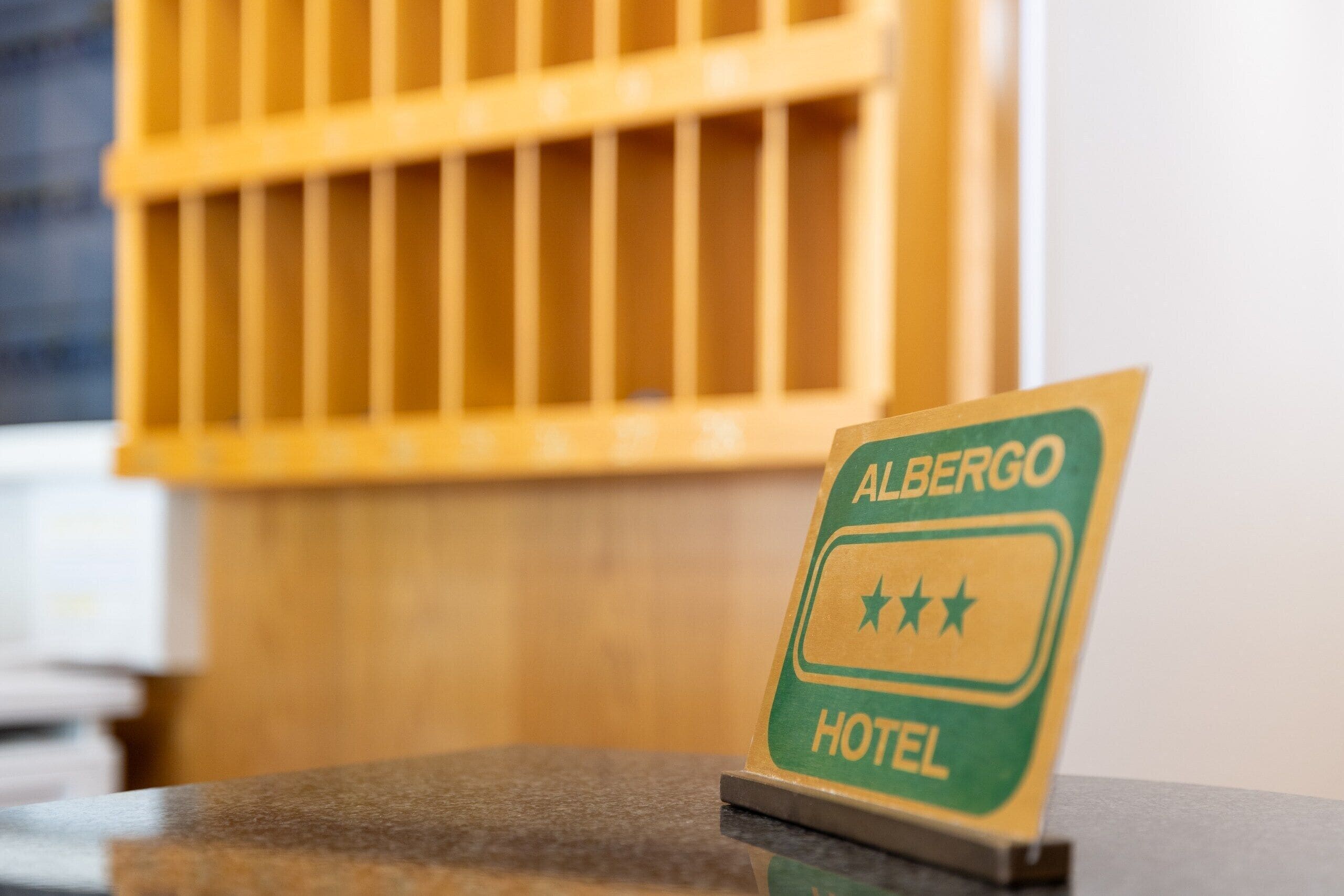 Ein Hotelschild mit der Aufschrift 'Albergo' und drei Sternen.