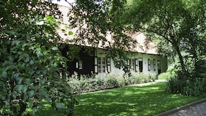 A traditional house with a garden, surrounded by lush greenery. - Hotel Landhuis ' T Wilgenerf (Ypres)
