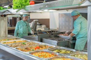 A buffet setup with various food items and two staff members in uniform. - Sunrise All Suites Resort (Nessebar)