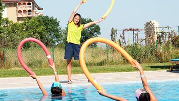 Una piscina con gente usando aros de hula.