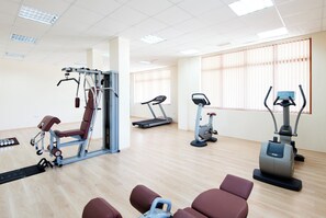 A fitness center with cardio machines, weight training equipment, and a mirror wall. - Sunrise All Suites Resort (Nessebar)