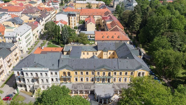 Un grand bâtiment historique doté d’une cour intérieure, entouré d’autres bâtiments.