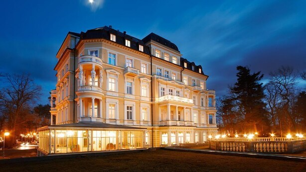 A multi-story building with a classical architectural style, featuring a central courtyard and multiple balconies. - Imperial Spa Hotel (Frantiskovy Lazne)