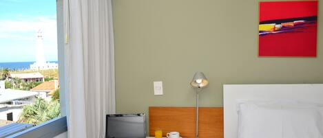Habitación de hotel con una computadora portátil, bandeja de desayuno y una lámpara.