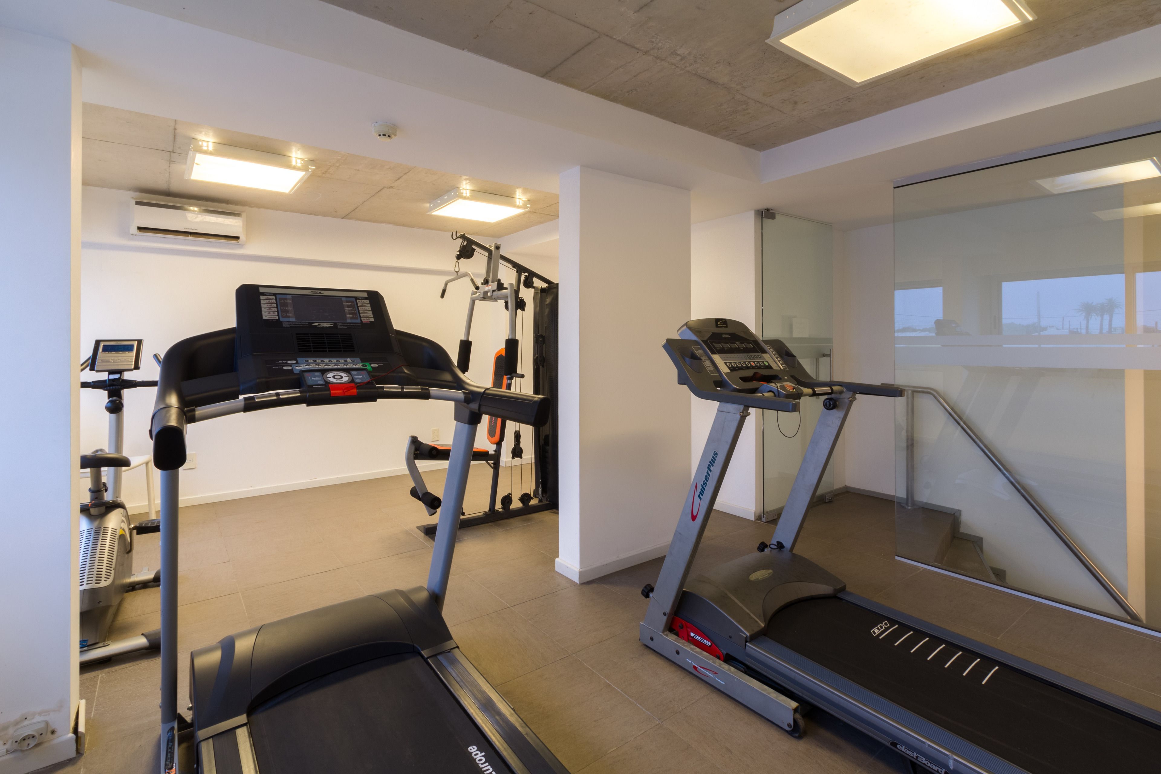 A gym with treadmills, a stationary bike, and a weight machine.