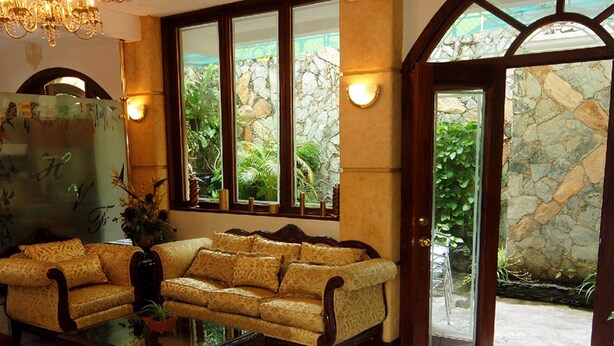 A spacious living area with a sofa set, a glass coffee table, and a chandelier.