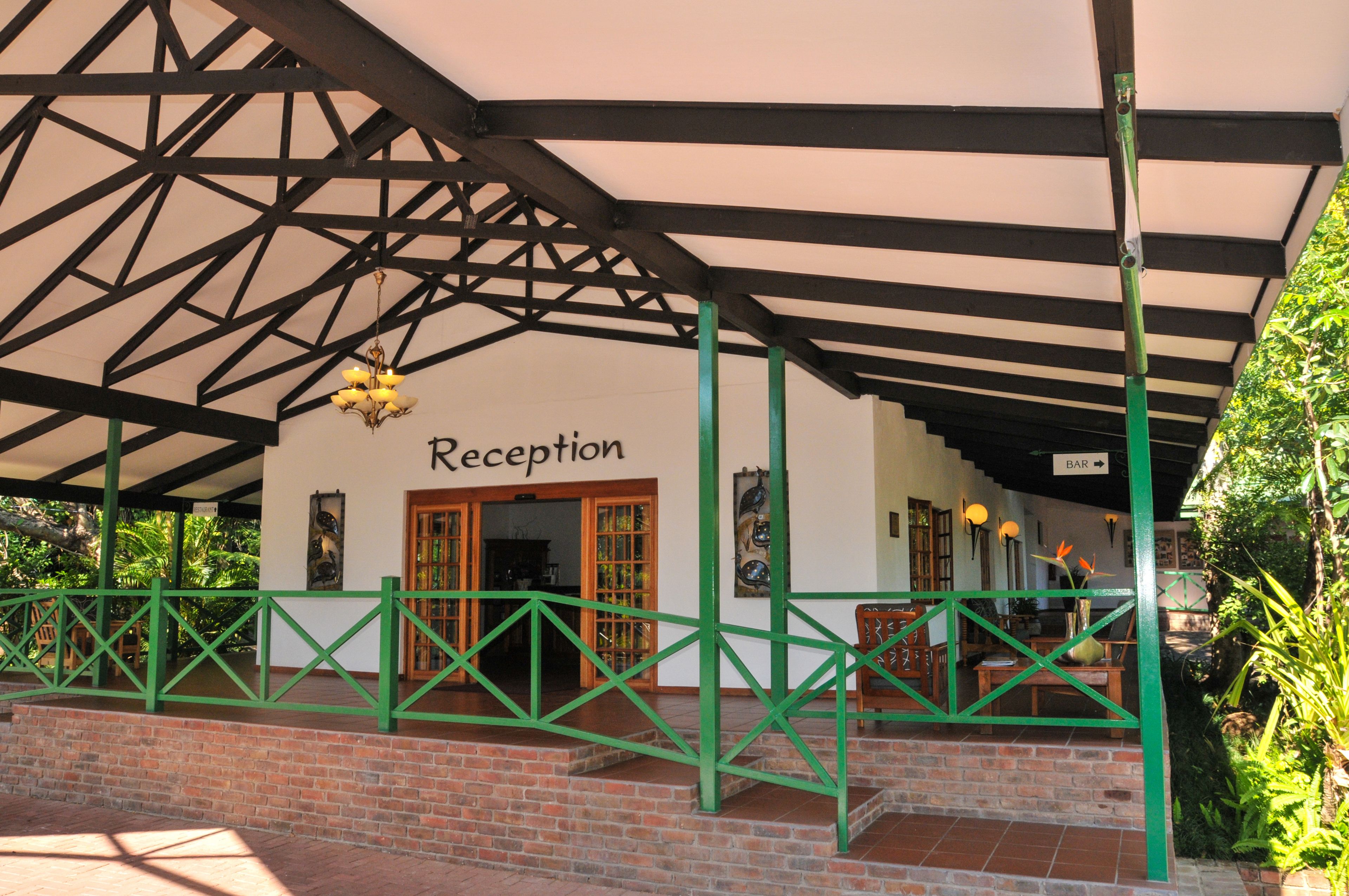 A reception area with a sign, a covered entrance, and a brick wall.