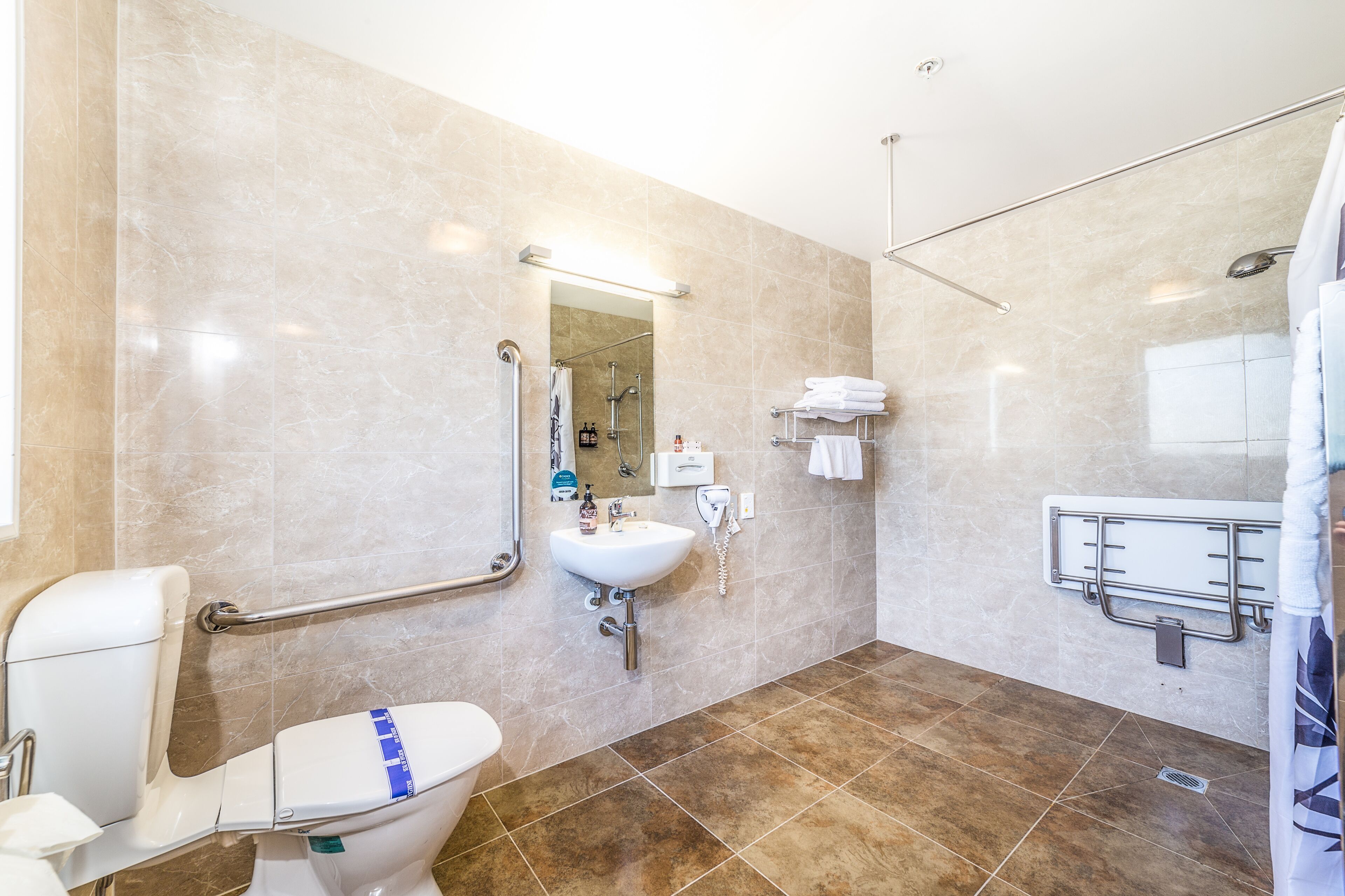A modern bathroom with a toilet, sink, and shower area.