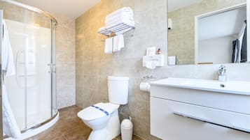 Une salle de bain moderne avec une douche à parois de verre, des toilettes, un lavabo et un porte-serviettes.