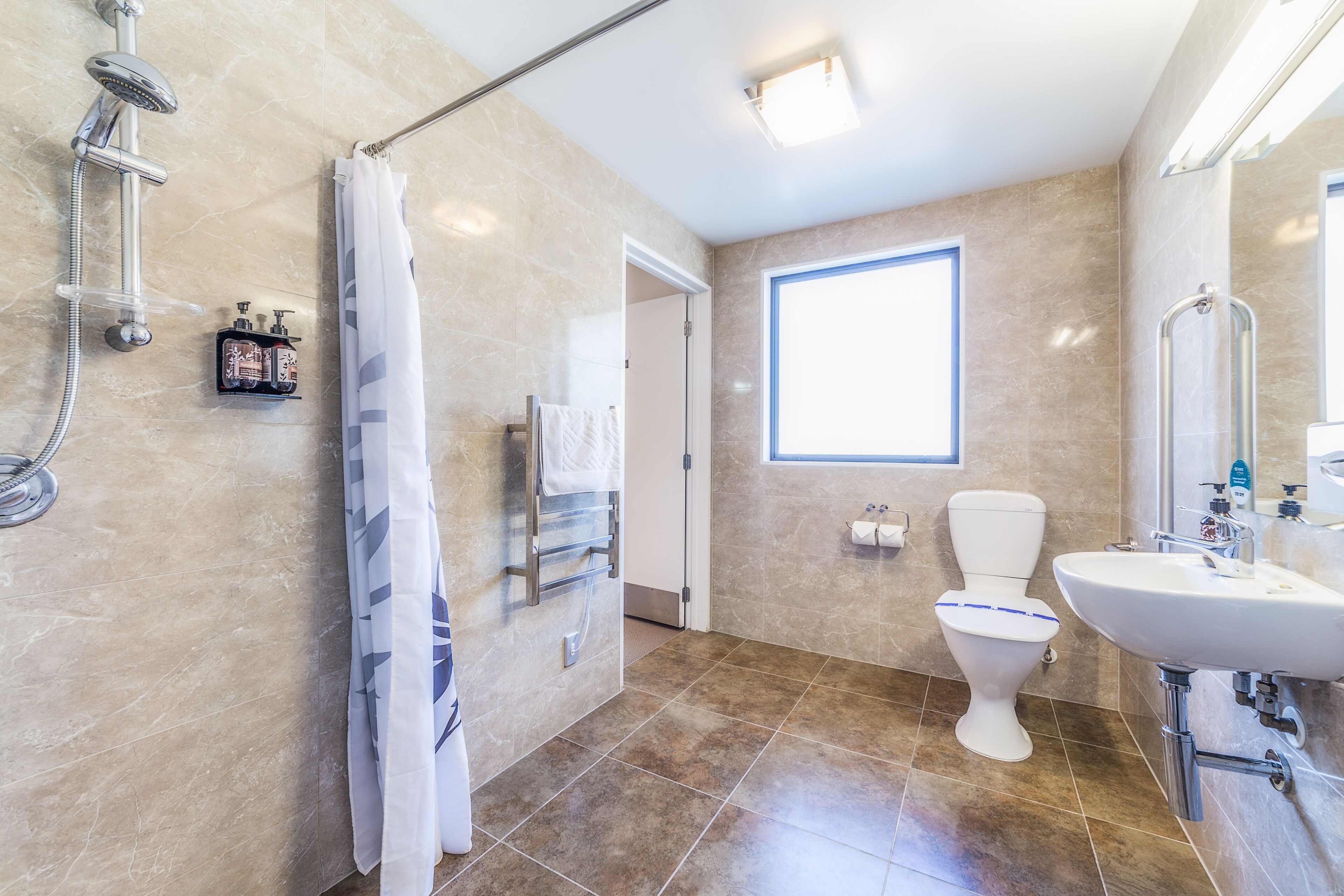 Un baño moderno con ducha, inodoro y lavamanos.