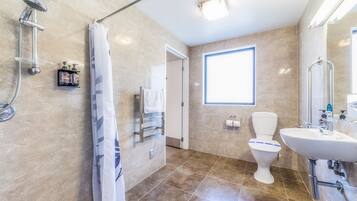 Un baño moderno con ducha, inodoro y lavamanos.