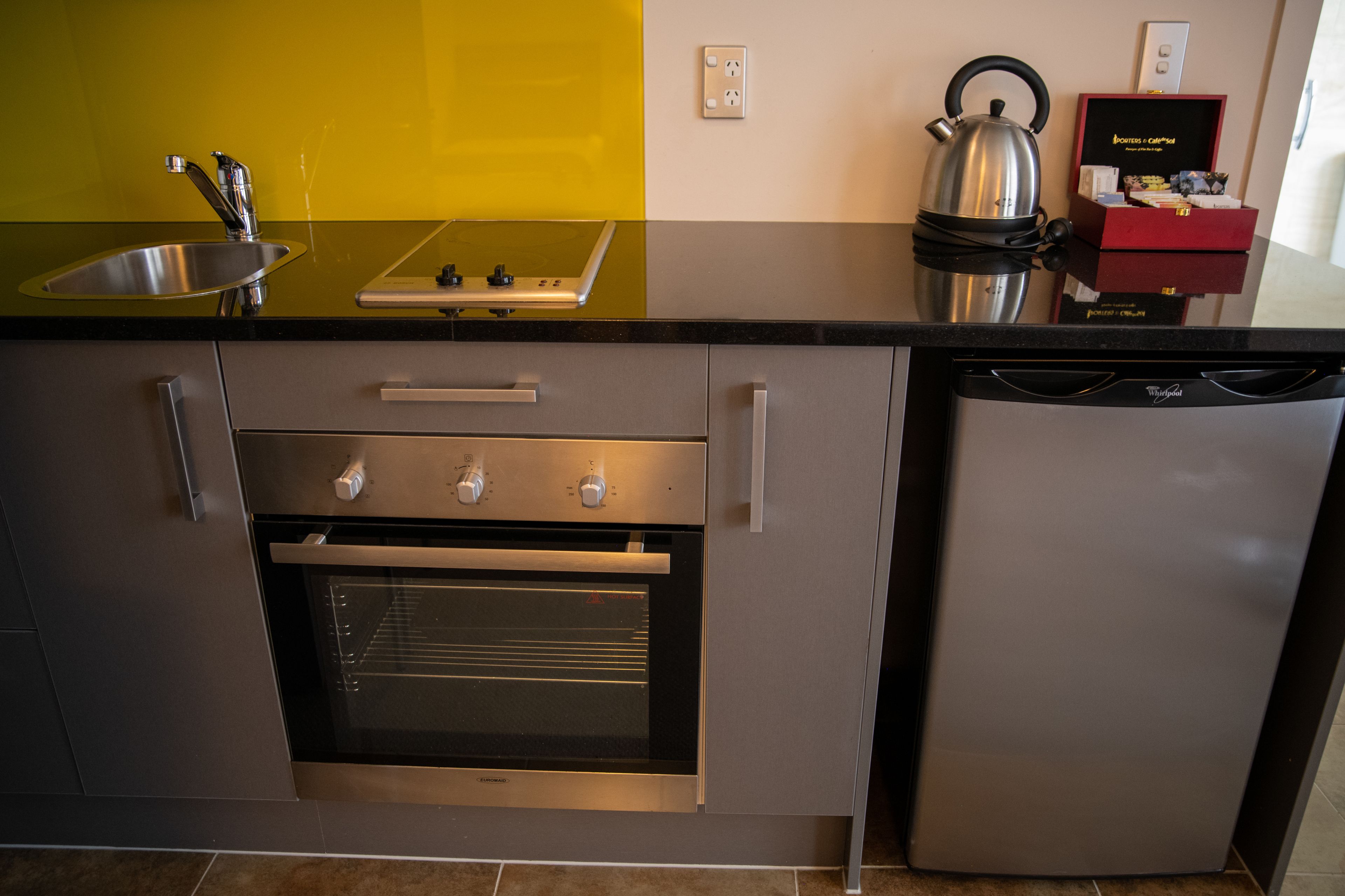 A modern kitchen with a stainless steel sink, a built-in oven, and a dishwasher.