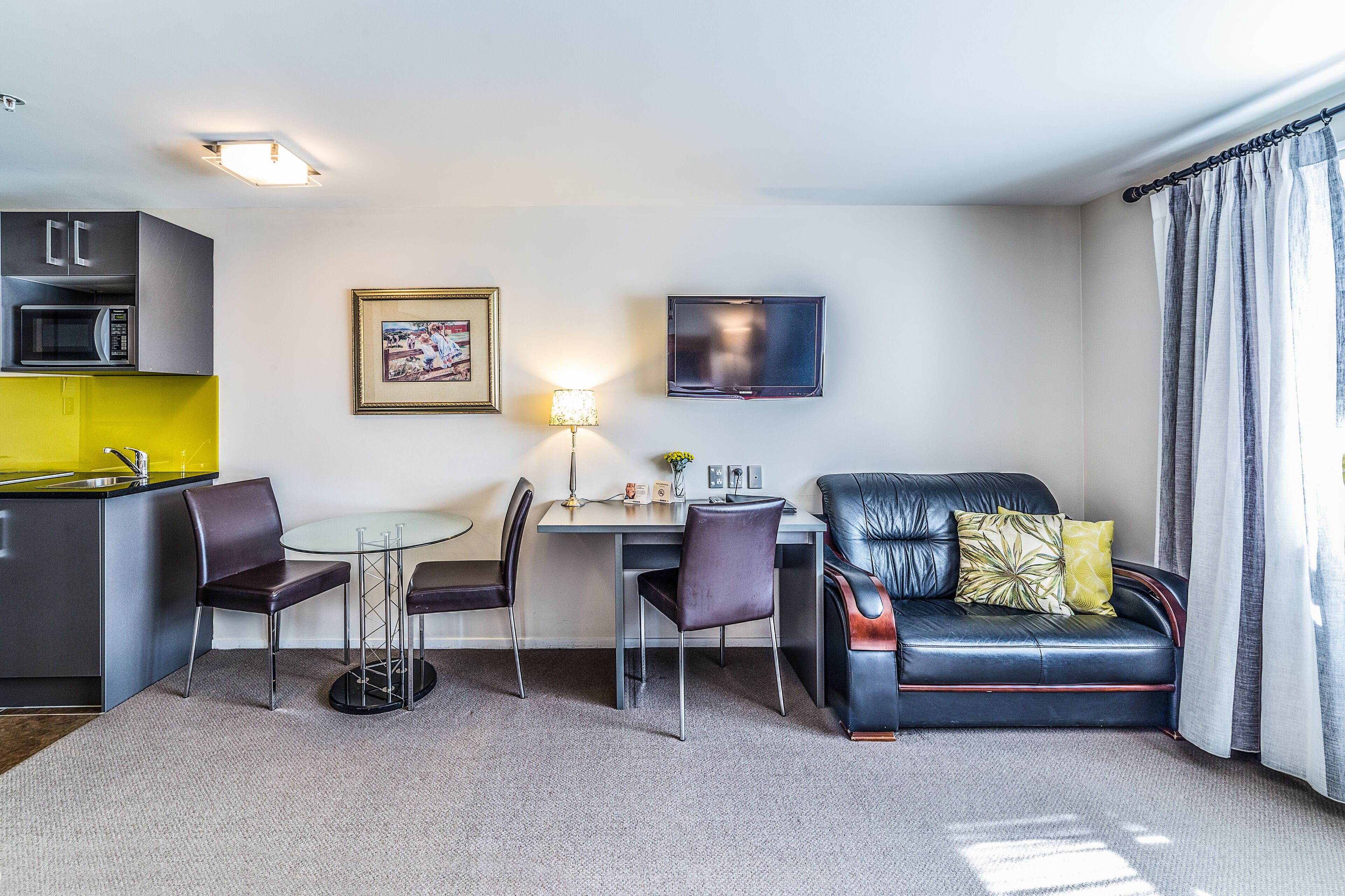 A compact living space with a kitchenette, dining area, and seating area.
