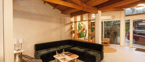 A cozy living room with a sectional sofa, a small coffee table, and a wicker chair.