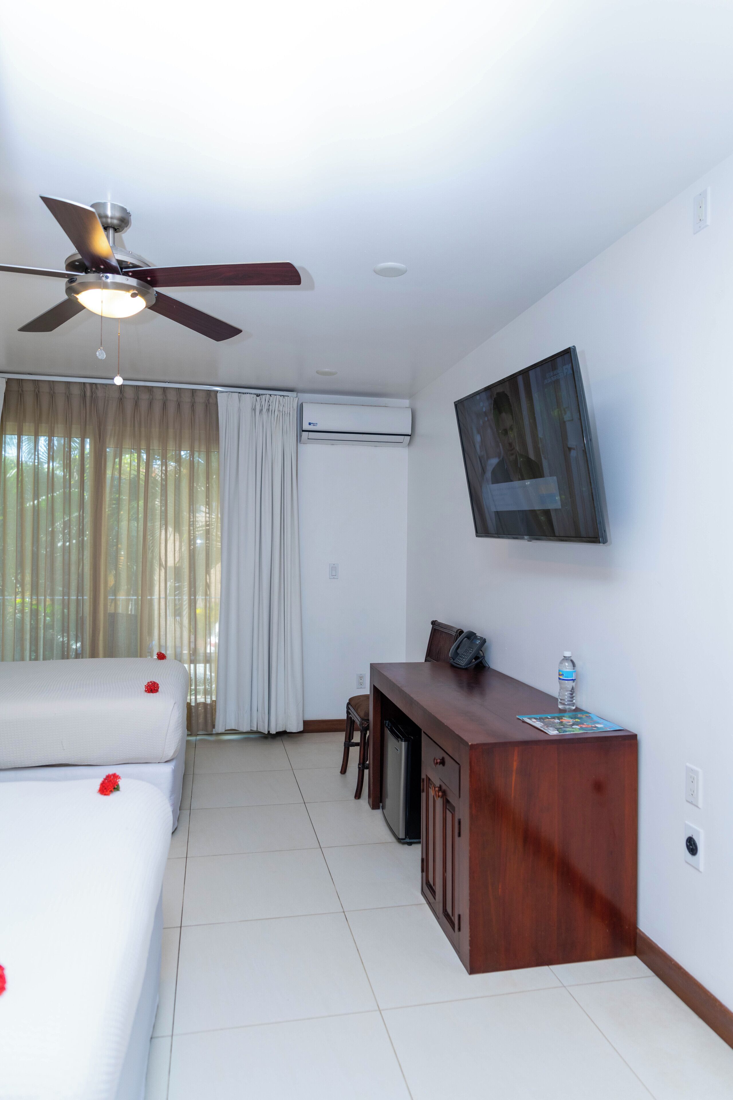 Une chambre d’hôtel équipée d’un lit, d’un bureau, d’une chaise, d’une télévision et d’un appareil de climatisation.