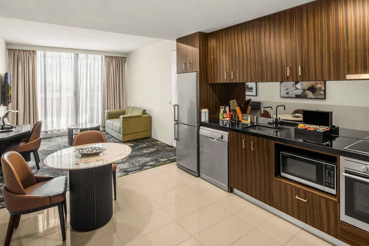 Una cocina moderna con comedor, sofá y televisor.