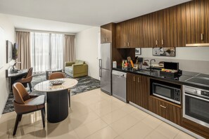 Uma cozinha moderna com área de jantar, geladeira, micro-ondas e lava-louças.