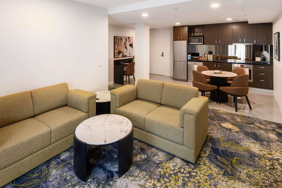 Una sala de estar moderna con un sofá, una mesa de centro y un comedor con sillas.