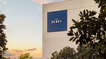 A building with a sign reading 'THE SEBEL' on a modern facade.