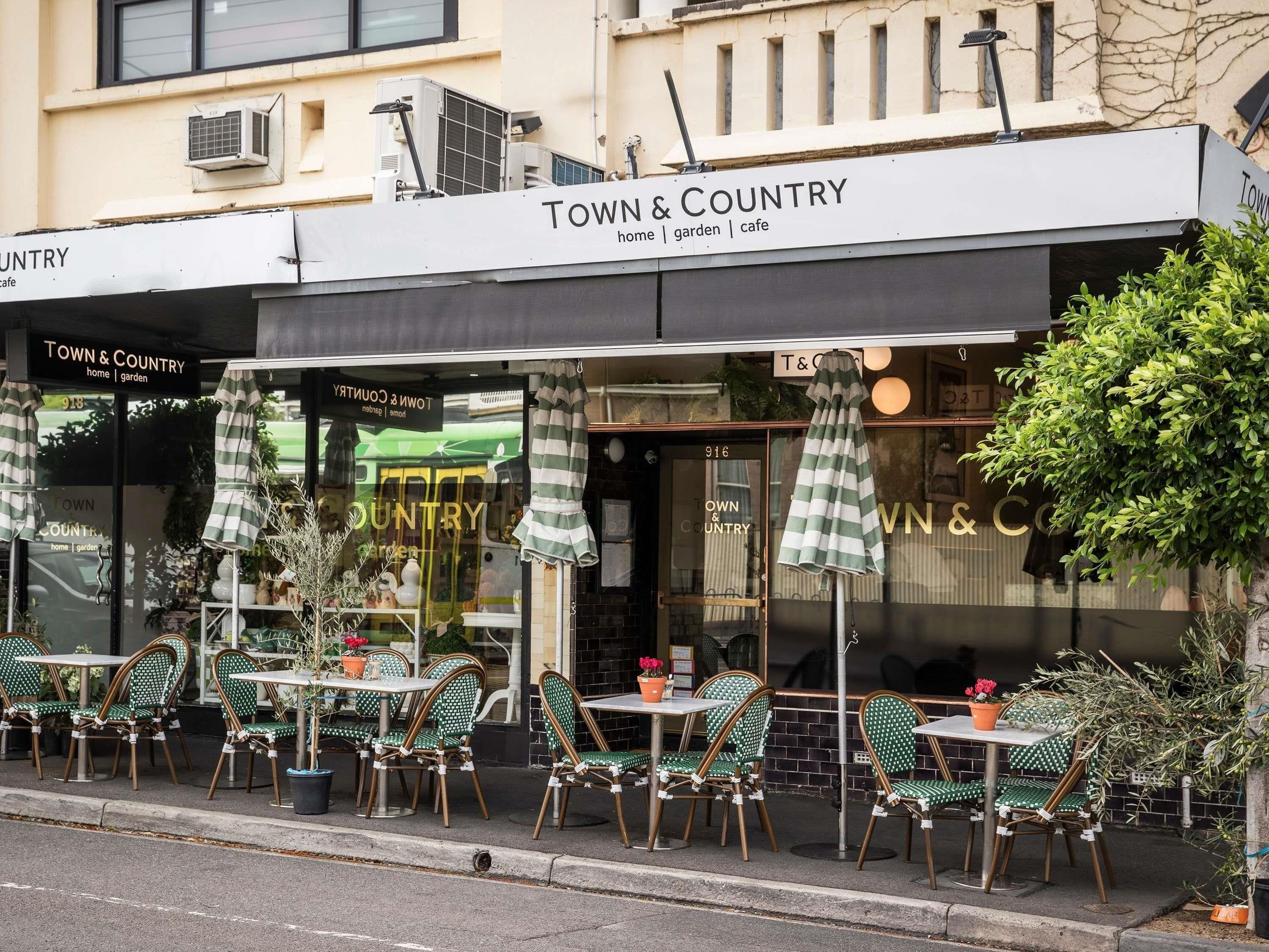 Un café llamado 'Town & Country' con terraza y un cartel sobre la entrada.