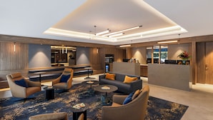 A modern lobby with seating areas, a reception desk, and a kitchen in the background. - The Sebel Melbourne Kew (Kew)
