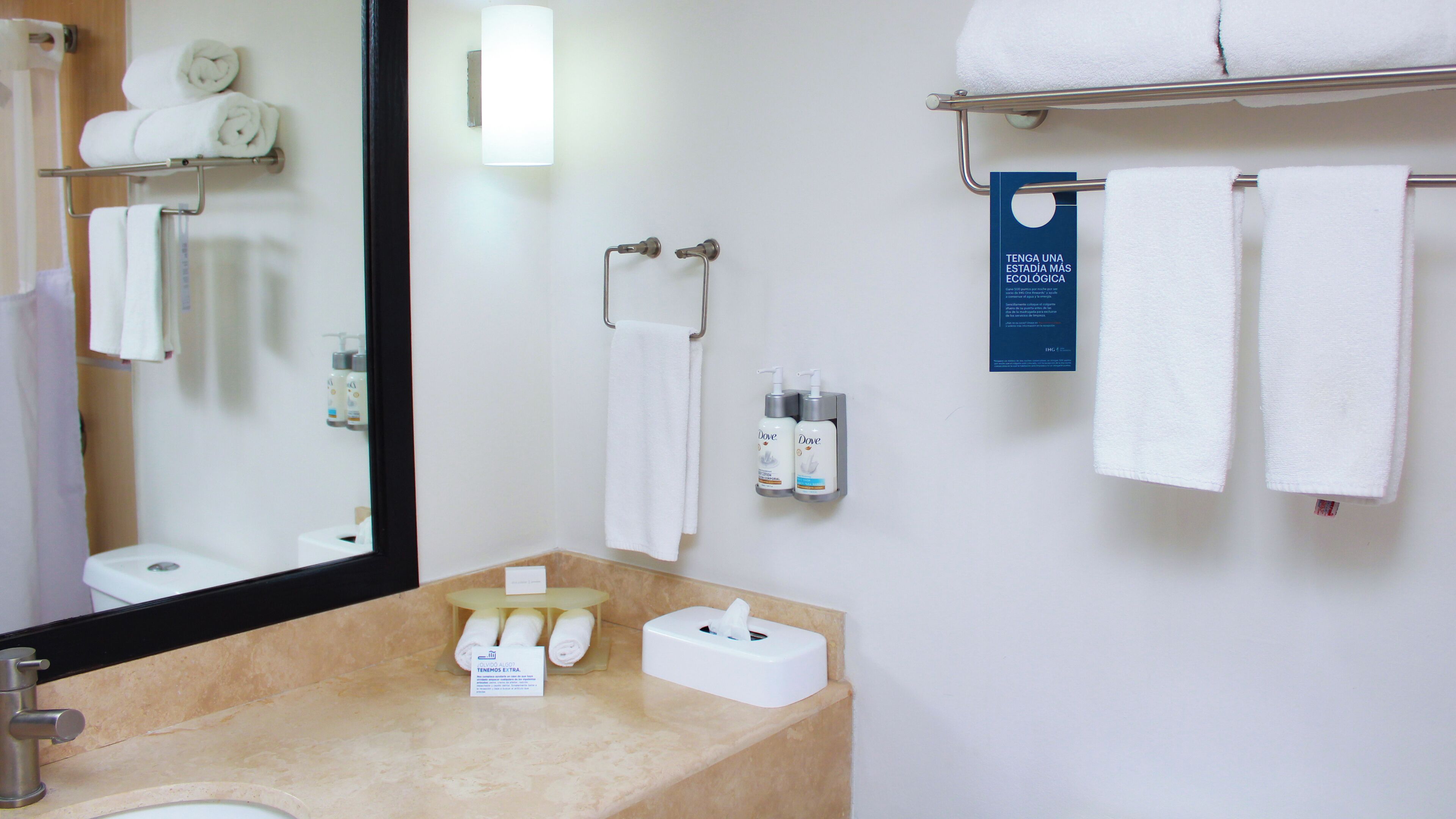 A bathroom with a sink, mirror, towel rack, and toiletries.