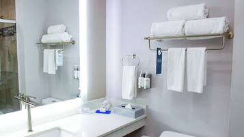 Un bagno moderno con un grande specchio, lavandino bianco e portasciugamani.