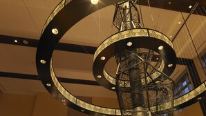 Eine Wendeltreppe mit kreisförmigem Design, umgeben von Bücherregalen und einer Sitzecke mit Kissen.