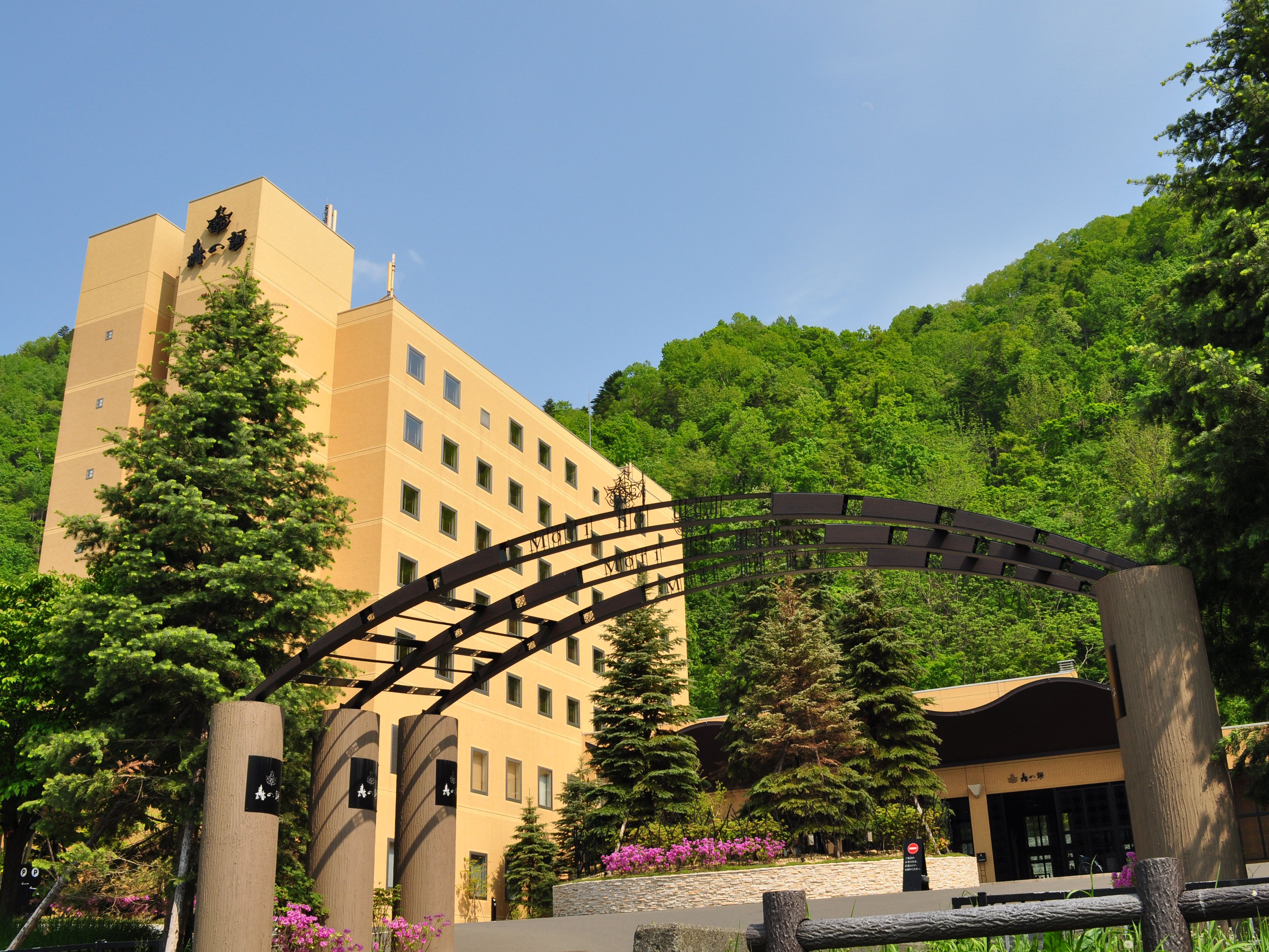 A hotel with a modern design, featuring a prominent entrance with a metal archway and a large building with multiple windows.