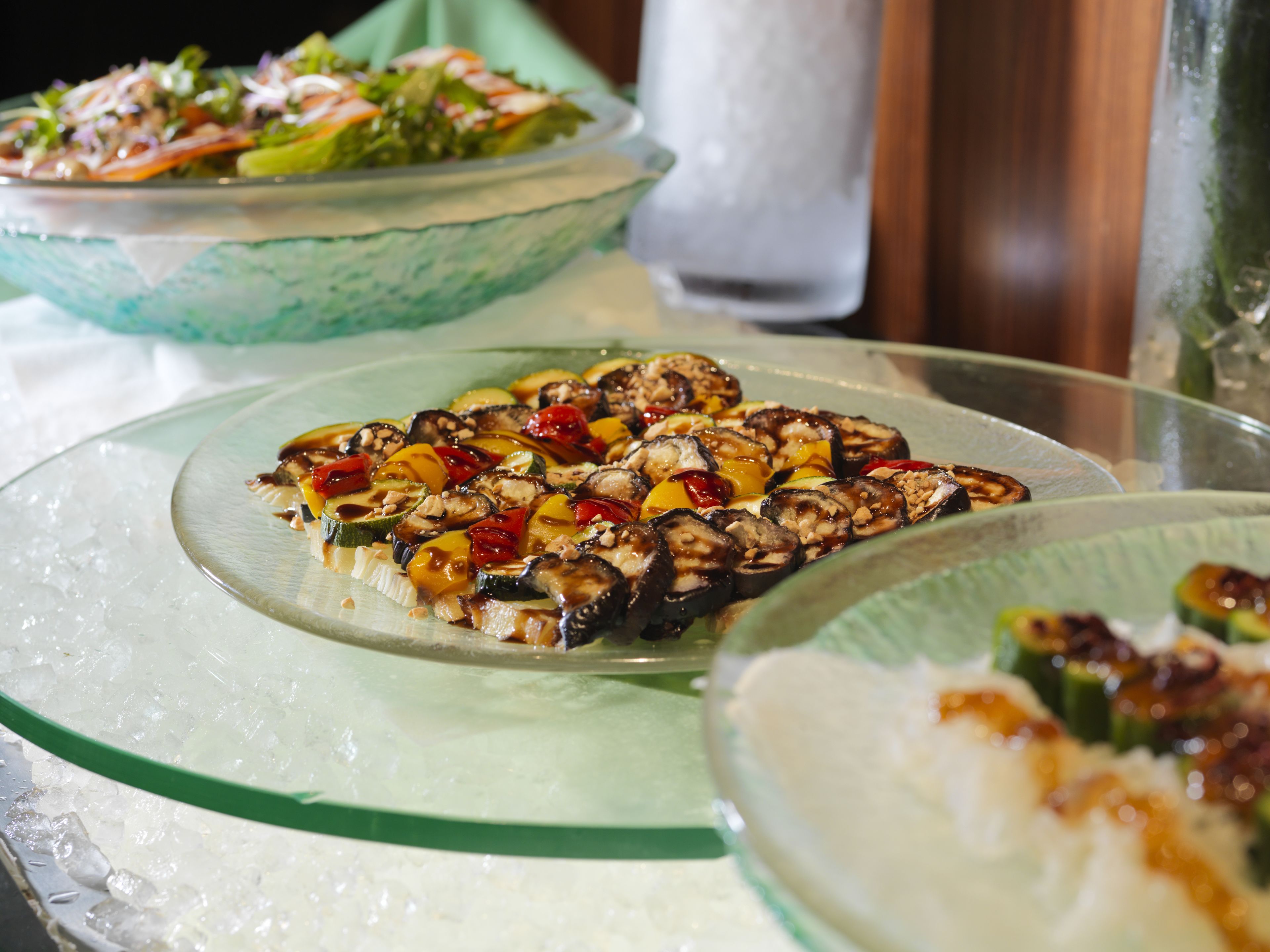 A dining table with various dishes, including a salad and a vegetable platter.